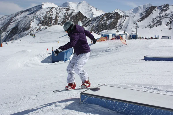 Joven snowboarder mujer deslizándose en una caja . — Foto de Stock