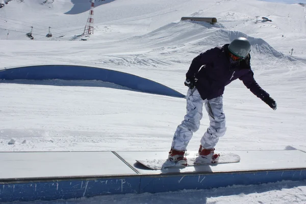 Young snowboarder woman sliding on a box. — Stock Photo, Image