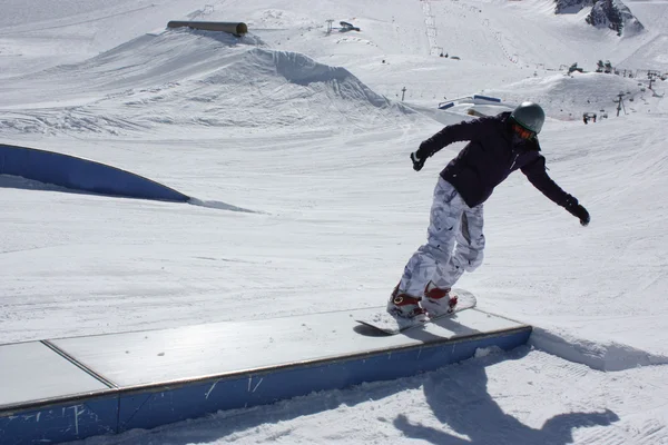 Молодая сноубордистка скользит по ящику . — стоковое фото