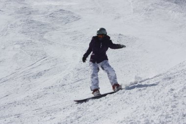 Genç snowboard kadın yokuş aşağı kayar.