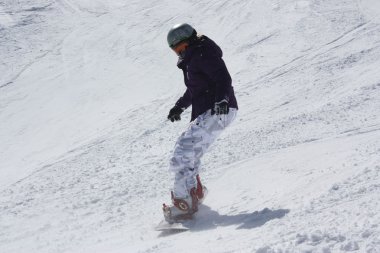Genç snowboard kadın yokuş aşağı kayar.