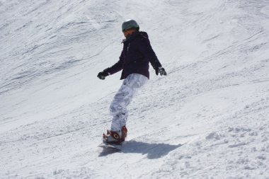 Genç snowboard kadın yokuş aşağı kayar.