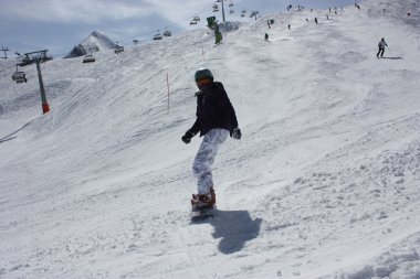 Genç snowboard kadın yokuş aşağı kayar.