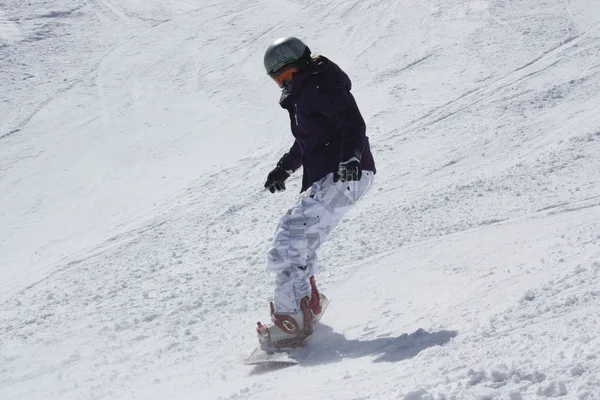 Unga snowboardåkare kvinna glider neråt. — Stockfoto