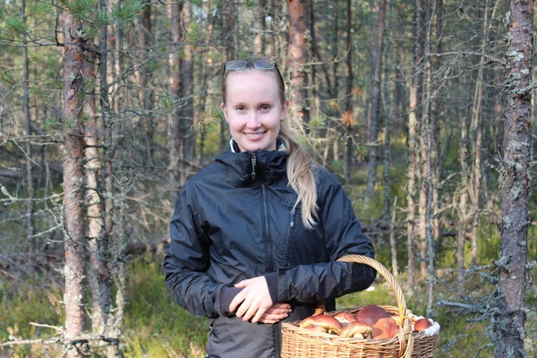 Young woman with a basket of mushrooms in the forest — Stock Photo, Image