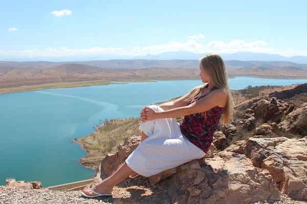 A young woman sit on the rock. — Stock Photo, Image