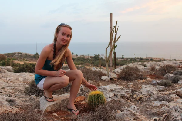 Young woman sitting near the cactus. — Stock Photo, Image