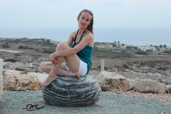 Young woman sit on the stone. — Stock Photo, Image