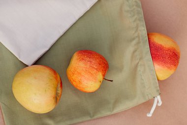 Kağıt üzerinde kırmızı elmalar olan yeşil meyve torbası. Sıfır atık kavramı, ekoloji ve çevrenin korunması