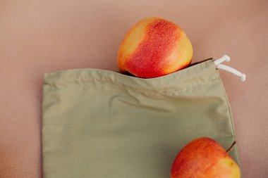 Kağıt üzerinde kırmızı elmalar olan yeşil meyve torbası. Sıfır atık kavramı, ekoloji ve çevrenin korunması
