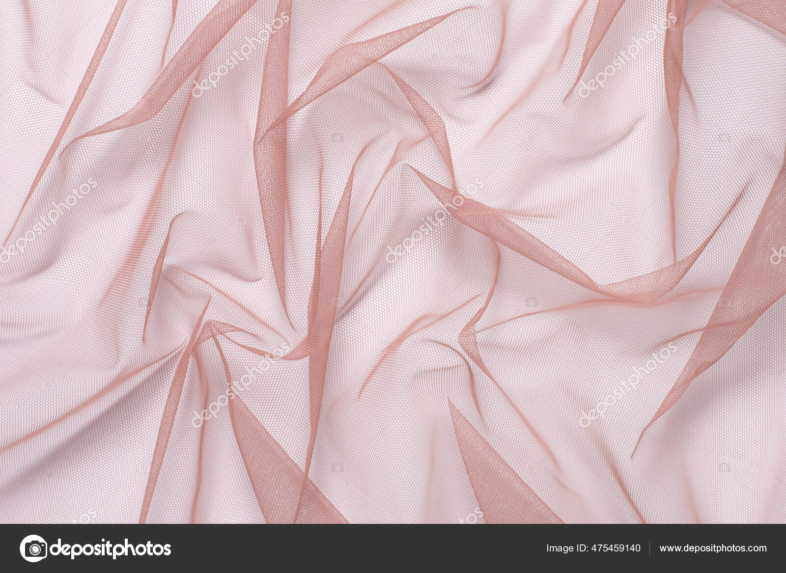 Tela de tul rosa arrugada y comprimida sobre una superficie blanca de cerca