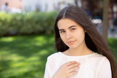 Kahverengi gözlü, saçları yeşil çimenlerin arka planında gelişen esmer bir kızın yakın çekimi. dizaynınız için yer