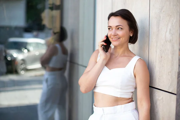 Una Mujer Adulta Con Traje Blanco Habla Por Teléfono Mientras — Foto de Stock
