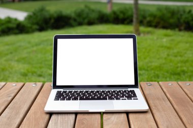 Reklam metni için beyaz arkaplan ile bilgisayar ekranı boş modeli. Uzaktan kumandalı konsept. Tahta bir masada dizüstü bilgisayar duruyor.