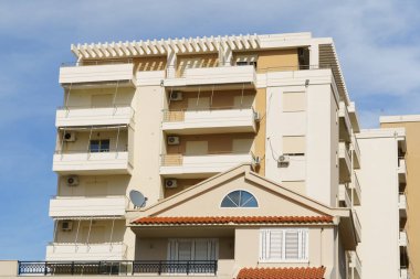 Pastel renkli kiremit çatılı bir sahil villası turkuaz suyun yanında yer alır. Tatil kiracıları, bölgesel mimari arayıcıları, yurtdışında mülk satın alanlar ve deniz kenarındaki yaşam tarzı tutkunları için harika.