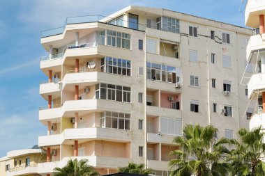 Pastel duvarları ve taş balkonları olan Parlak Akdeniz evi Arnavutluk caddesinde duruyor. Kıyı gayrimenkulleri, uzun vadeli kiralar ve deniz kenarında rahat yaşam kavramı.