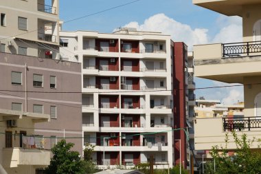 Güneşli teraslar ve beyaz cepheler Arnavutluk 'taki Akdeniz daireleri kümesini tanımlıyor. Kiracılar, ev sahipleri, taşınma arayanlar ve deniz kenarında barınma olanakları sunan emlak acenteleri