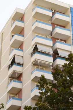 Dikdörtgen şekilli, açık renkli Akdeniz apartmanı. Kiralama, taşınma, kıyı yatırımları ve mevsimlik konaklama hizmetleri sunan emlak acenteleri için ideal