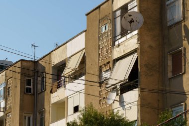 Beyaz solgunluklar ve dar balkonlar, Arnavutluk kıyısı yakınlarında sakin bir yerleşim bölgesi oluşturuyor. Birimler kiracıların, yatırımcıların, taşınma planlarının ve deniz kenarındaki konutları yöneten acentelerin ihtiyaçlarını karşılıyor