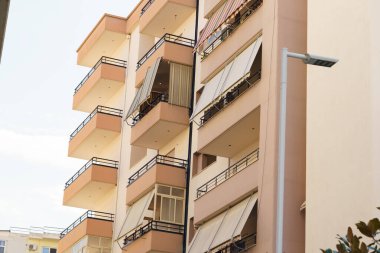 Akdeniz 'de geometrik balkonları ve düz duvarları olan çağdaş Arnavut binası. Kiralık eşyalar, emlak alımları, taşınma ihtiyaçları, seyahat konaklama ve emlak araçları için uygun.