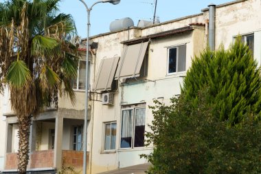 Akdeniz etkisi, düz yüzeyler ve klasik pencere çerçeveleriyle geleneksel Arnavut cephesi. Uzun vadeli kiraya, emlak alımına, taşınma hedeflerine ve tatil ziyaretlerine elverişli.