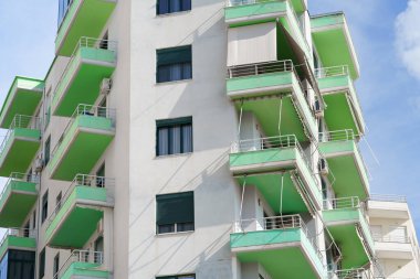 Arnavutluk kentsel ortamı içinde Akdeniz geleneğinde modern konut binası. Emlak kiralama, satın alma olanakları, taşınma desteği ve ajans portföyleri için uygundur.