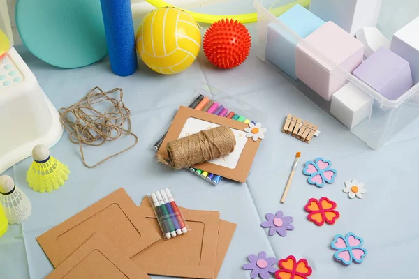 Çocukluk gelişimi için çeşitli öğelerin yüksek açılı görünümü. Renkli sanat, yaratıcı fiziksel aktiviteler için spor malzemelerini mavi arka planda sergiliyor. Okul terapisi kavramı.