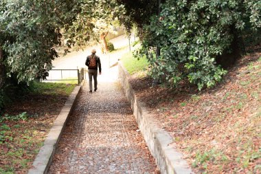 Sonbaharda ormanda yolda yürüyen bir adam..