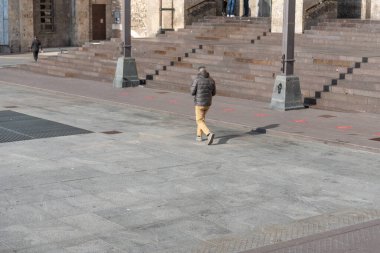 Adam boş meydanı yaya olarak geçiyor.