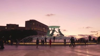 Valletta, Malta, gün batımında Triton Meydanı 'ndaki insanlar.