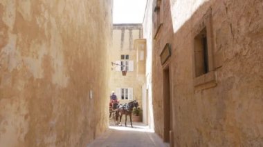 Mdina, Malta, at arabası tipik dar bir sokakta.