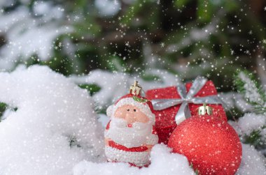 Karla kaplı bir ladin dalında Noel kırmızı dekoru.