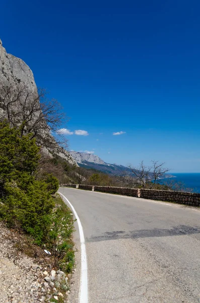 Pittoreska fjällsommaren landskap med havsutsikt. En slingrande väg vid foten av ett berg, Krim. Resor och semester koncept. Stockbild