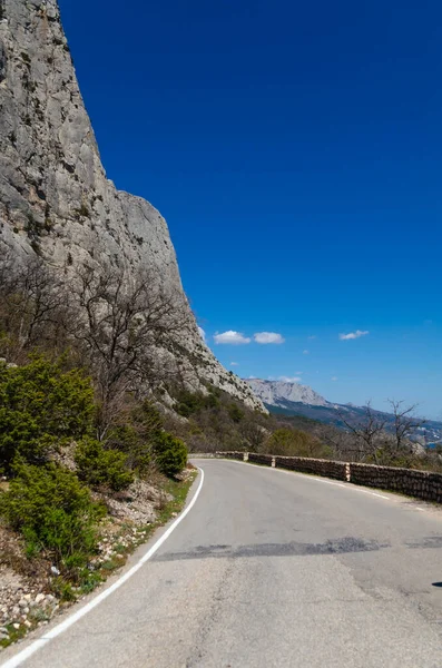 Pittoresk utsikt över bergen med havsutsikt. En slingrande väg i bergen, Krim. Resor och semester koncept. Royaltyfria Stockbilder