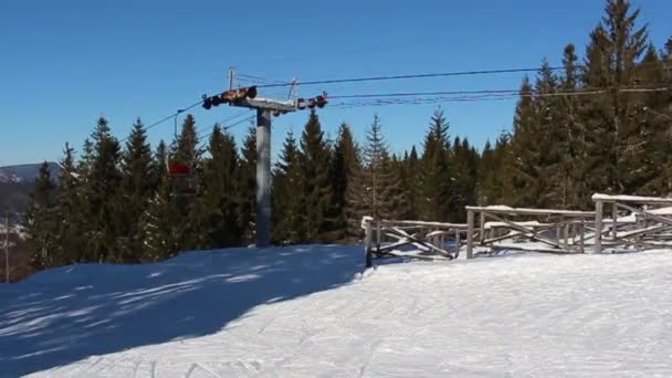 Лыжный подъемник и женщина на лыжах рядом — стоковое видео