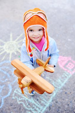 Çocuk bir arka plan üzerinde ahşap oyuncak uçak ile kız bebek