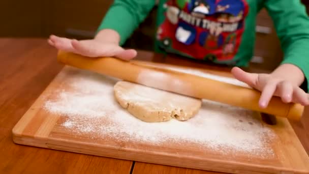 Manos de los niños primer plano desplegar la masa para pan de jengibre con un rodillo de madera. — Vídeos de Stock