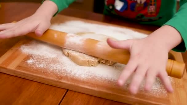 Manos de los niños primer plano desplegar la masa para pan de jengibre con un rodillo de madera. — Vídeo de stock