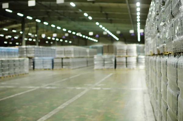 Enorme almacén industrial con plástico envoltura de alimentos botellas de plástico envueltas con bebidas carbonatadas, agua o cerveza. — Foto de Stock