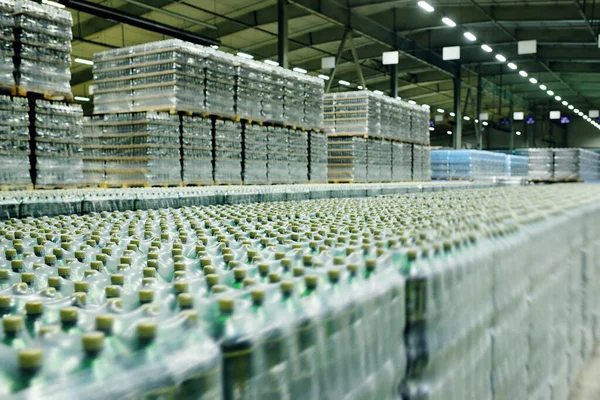 Almacén industrial de alimentos para almacenamiento y almacenamiento de tetrapacks con bebidas, agua, cerveza en botellas de plástico. —  Fotos de Stock