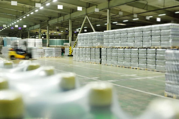 Enorme almacén industrial con plástico envoltura de alimentos botellas de plástico envueltas con bebidas carbonatadas, agua o cerveza. —  Fotos de Stock