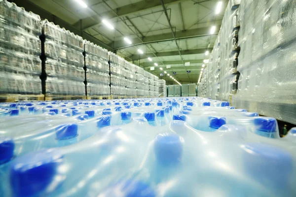 Almacén industrial de alimentos para almacenamiento y almacenamiento de tetrapacks con bebidas, agua, cerveza en botellas de plástico. — Foto de Stock