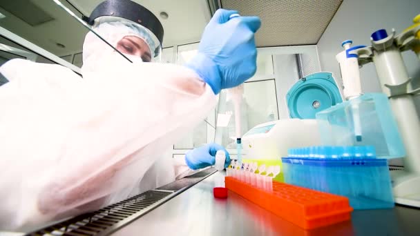 Pracovnice laboratoře PCR v ochranném lékařském obleku, sterilní maska, helma, gumové rukavice s dávkovačem v rukou — Stock video