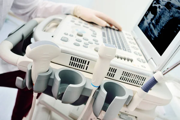 Médicos mãos em luvas médicas close-up contra o pano de fundo de uma moderna máquina de ultra-som — Fotografia de Stock