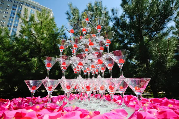 香槟酒洒在粉色玫瑰花瓣的背景上 — 图库照片