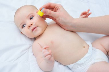 Sevgili anne, oğluna burun damlası enjekte eder..