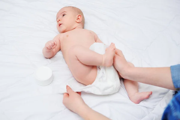 As mãos da mãe põem a fralda de bebês. — Fotografia de Stock