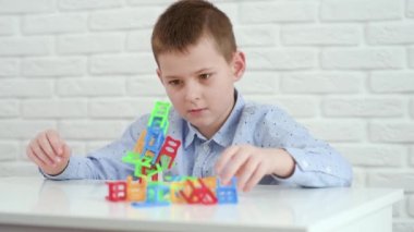 Bebek çocuk oyuncak sandalyelerden bir kule inşa ediyor..