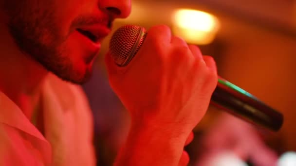 Cantante masculino canta en un micrófono en el karaoke o en un club nocturno. — Vídeos de Stock