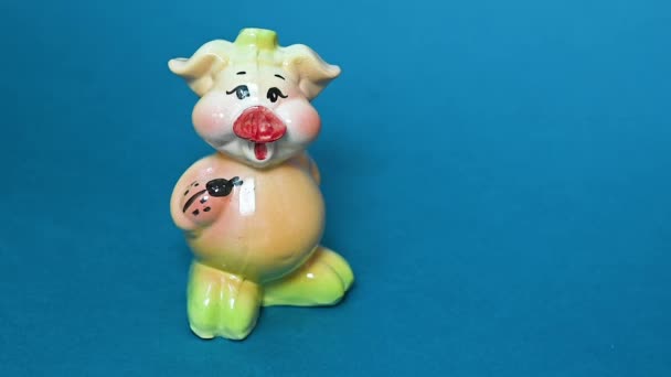 Mão com um martelo quebra um porquinho de porcelana na forma de um porco — Vídeo de Stock